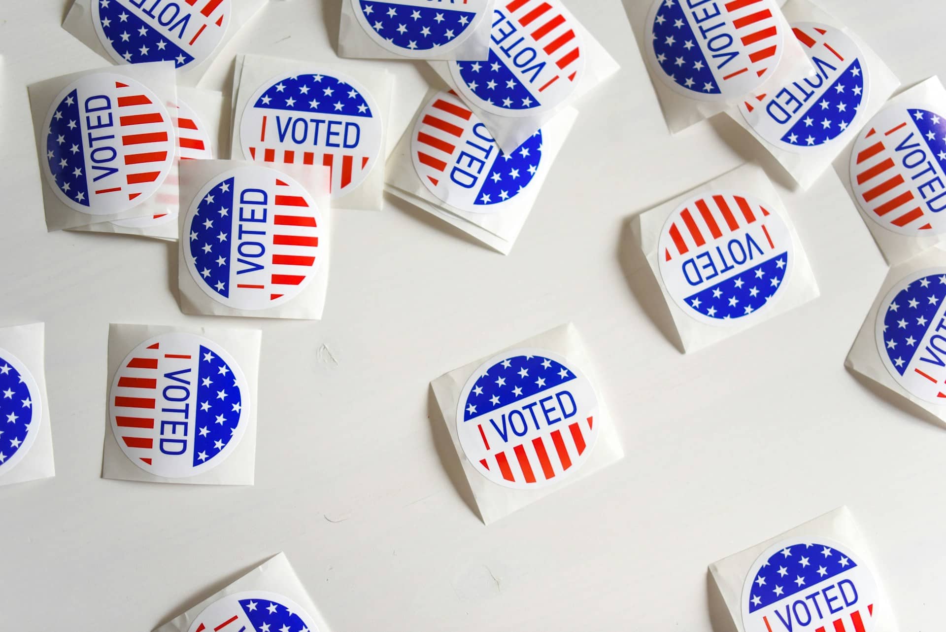 small round I Voted badges with American flag colours on a white background