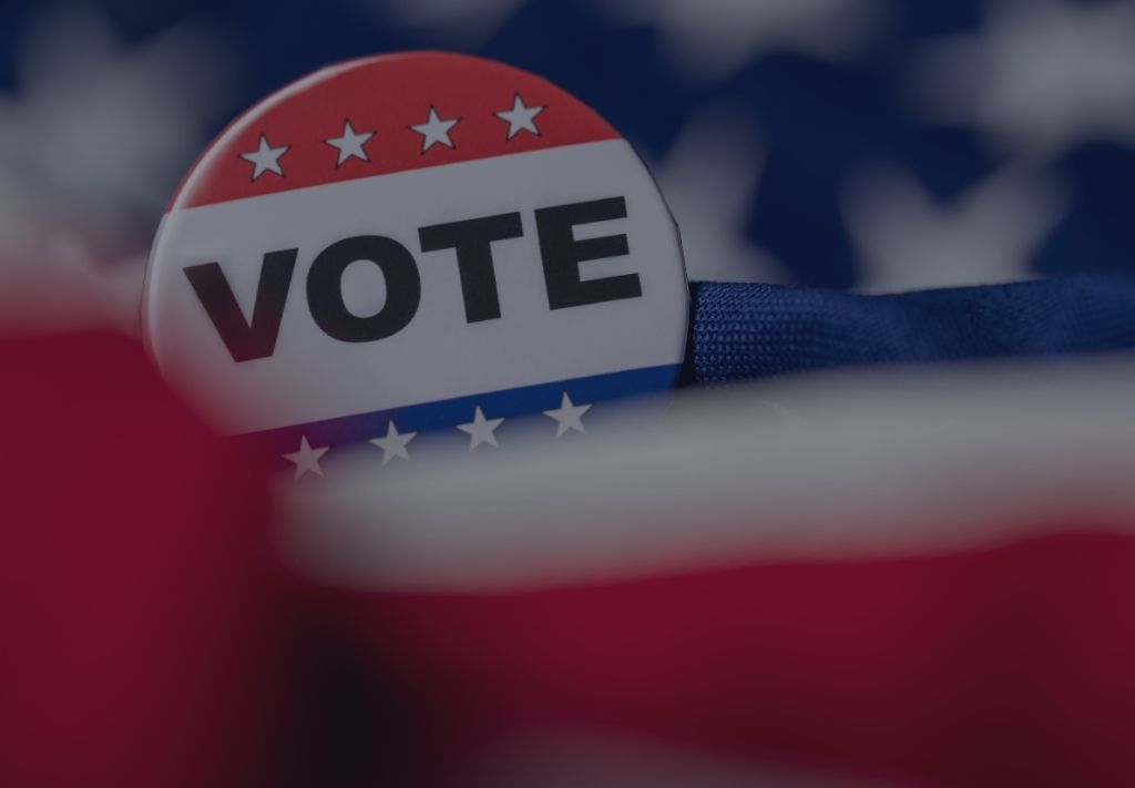 red white and blue badge with vote on it